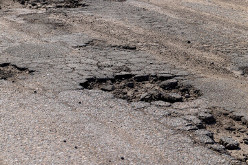 Fototapeta na wymiar poor paved road with a lot of holes and potholes
