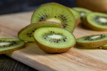 sliced green kiwi fruit on a wooden board