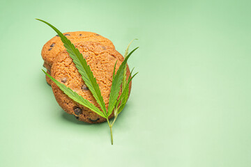 Cannabis chocolate chip cookies with a marijuana leaf on a green background