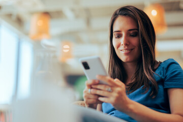 Happy Woman Holding Her Smartphone Communicating in Chat Messages. Carefree millennial girl browsing dating app smiling with confidence
