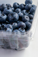 blueberries in a bowl on white table with copy space 