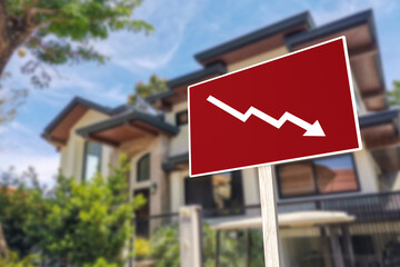 A sign showing an downward arrow in front of a house. Concept of decreasing or slumping home prices...