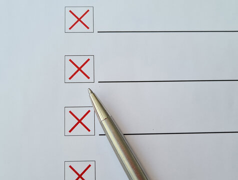 Ballpoint Pen Crosses Off Checklist Items With A Red X On White Paper