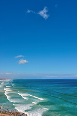 Beautiful and relaxing view of ocean, beach and a cloudy blue sky with copy space background. Landscape of calm and remote sea with waves rolling onto the shore in natural environment on a sunny day