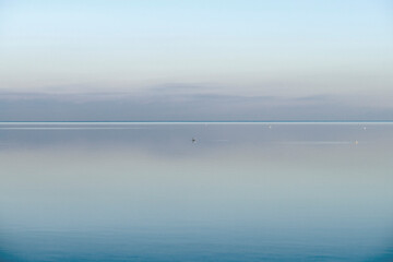 Calm, cool and relaxing front view of the ocean horizon, copy space on top. Mist over the sea on a new morning. Clear and blue sky during a tranquil dusk evening with natural background.