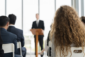 Senior business man speaking at podium speaker. Back view of diverse business people meeting at...