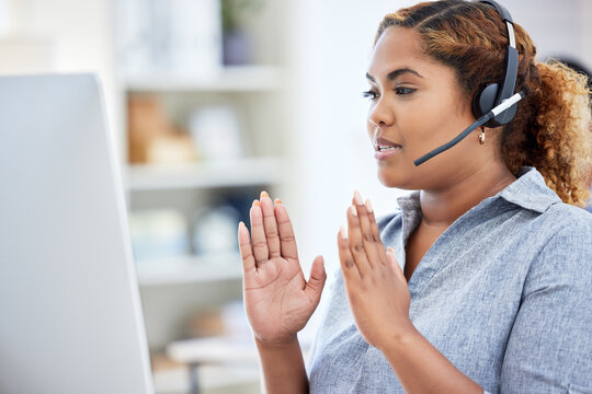 Online seminar, workshop, and meeting being had by a call center agent explaining, taking and having a conversation on a desktop computer while working in an office. Female giving customer service