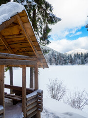 Winter forest in the Carpathians, Ukraine, near Lake Synevyr. Trees and gazebo covered in snow. Nature scenery with spruce trees in snow. Landscapes with coniferous forest on a bright sunny day.