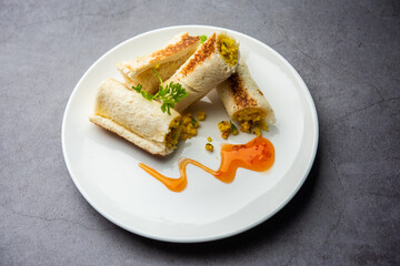 Indian paneer bread roll made using spiced grated cottage cheese mixed with spices & rolled & baked