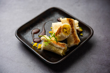 Indian paneer bread roll made using spiced grated cottage cheese mixed with spices & rolled & baked