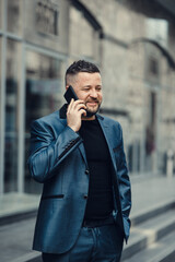 Businessman waiting for a meeting. Handsome smiling man.The businessman speaks by phone.