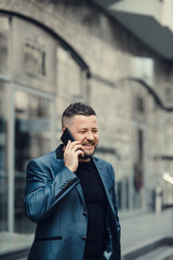 Businessman waiting for a meeting. Handsome smiling man.The businessman speaks by phone.