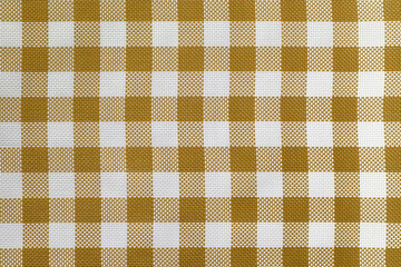 Checkered tablecloth for the table beige and white cells pattern. Background texture of brown textile napkin.