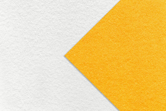 Texture of white and bright yellow paper background, half two colors with arrow. Structure of craft orange cardboard.