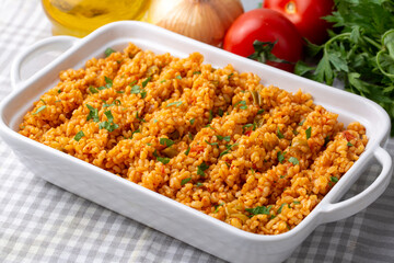 Traditional turkish bulgur pilaf with tomato sause in plate (Turkish name; meyhane pilavi)