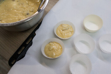 Muffins step by step cooking process. Top view. Concrete background. Mixing all ingredients together, making dough or batter and filling paper baking form. Pouring muffin dough into molds. Cupcakes
