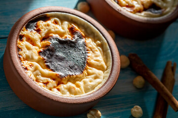 Baked rice pudding turkish milky dessert sutlac in earthenware casserole with hazelnuts