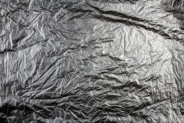 Authentic texture background of black plastic bag. black plastic crumpled bag in folds. Background...