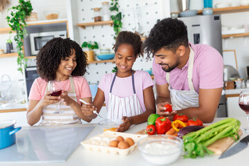 Family In Kitchen Making Morning Breakfast Together. Happy family in the kitchen having fun and cooking together. Healthy food at home.
