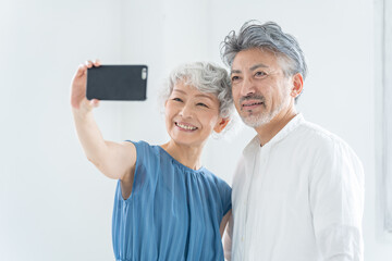 スマホで自撮りをするシニア夫婦