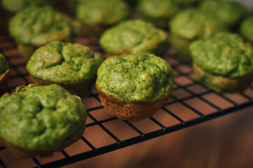 ready-made small green muffins with spinach on a baking sheet