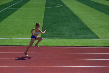 Fototapeta premium Young caucasian woman is engaged in jogging at the stadium outdoors.