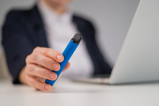 Business Woman Holding Disposable Vape While Sitting At Laptop. 