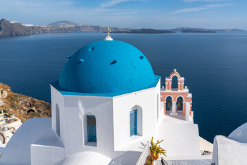 Famous blue domed church in Oia, Santorini, offering a beautiful panorama over the sea and the caldera, Greece