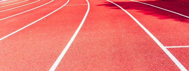 Athletic track,red surface and white lines closeup.Banner,advertisement.