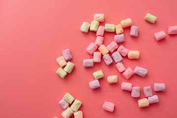 Multicolored candies on a pink background. Close-up