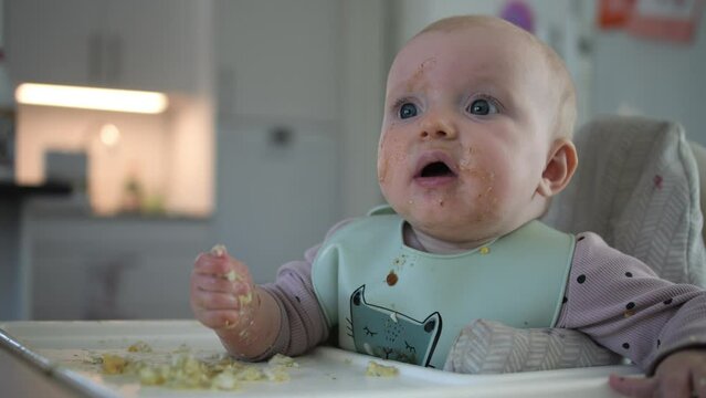Cute baby messing up with food. Fixed view. Real time