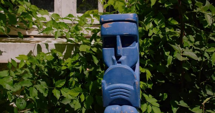 Blue Tiki Man Wooden Statue In A Garden. - Closeup Shot