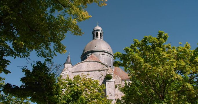 Collegiate Church Of Saint-Quiriace Framed With Trees Foliage On Blue Sky Background. Provins, France - Low-Angle Shot