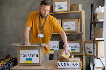 Volunteers collecting food donations in warehouse. Volunteer collect donations for Ukrainian...