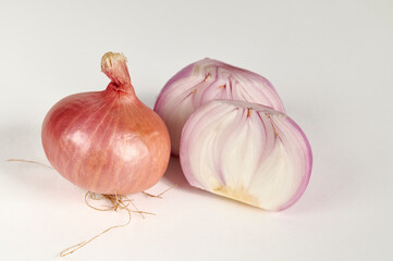 Red bulb onion and cut onion on a white background
