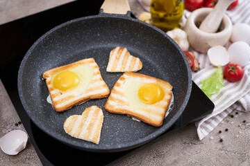 Heart shaped Fried Egg on Toast Bread in a pan at domestic kitchen