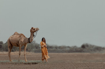 Indian woman with camel in desert