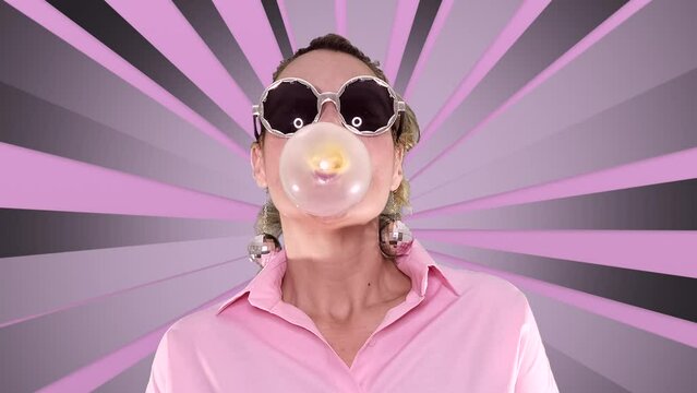 woman with party glasses chewing gum and make bubble on spinning pink rays background