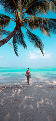 Woman walking towards water on tropical island