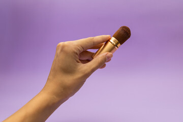 A girl holds a lipstick in her hand