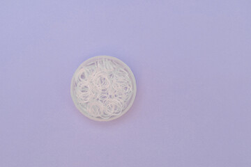 Disposable transparent hair bands on purple background