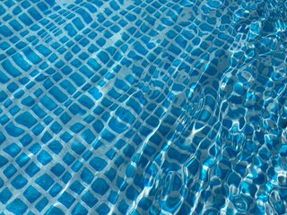 the reflecting water surface with waves in a blue pool