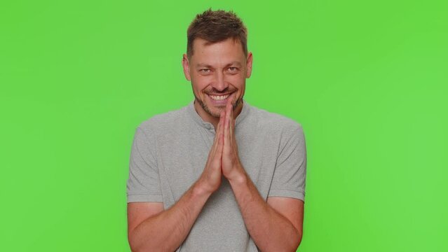 Sneaky cunning handsome man with tricky face gesticulating and scheming evil plan, thinking over devious villain idea, cunning cheats, jokes and pranks. Adult guy on green chroma key studio background