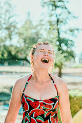 laughing emotional blonde woman with wet hair making water splashes. Holidays, happiness, fun, summer, leisure concept