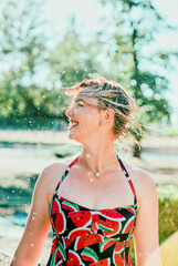 laughing emotional blonde woman with wet hair making water splashes. Holidays, happiness, fun, summer, leisure concept
