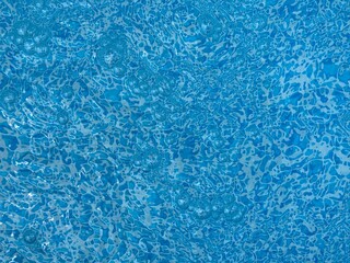 the reflecting water surface with waves in a blue pool