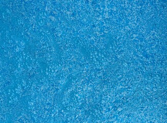 the reflecting water surface with waves in a blue pool