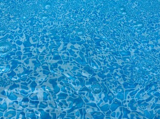 the reflecting water surface with waves in a blue pool