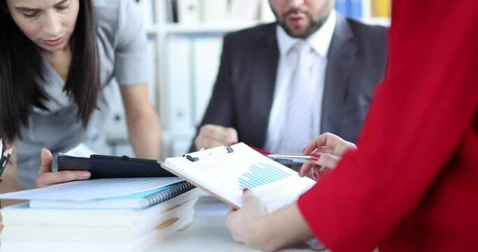 Puzzled people in the office look at documents with charts