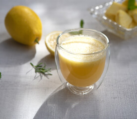 A glass of pineapple smoothie on wooden background with rays of the sun. Helthy food.